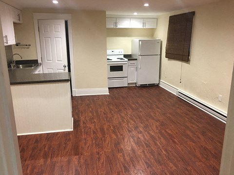 a kitchen with a wooden floor and a white refrigerator